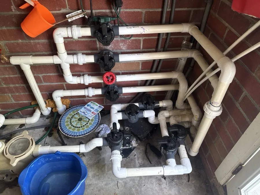 A manifold of pool valves and PVC plumbing, photographed up close